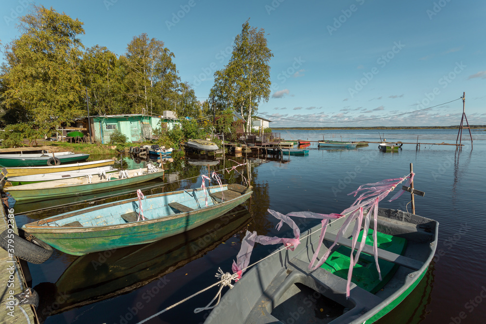 Scenic panorama with old wooden fishing boats on a picturesque lake in Russia.