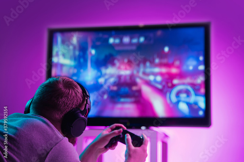 Принти на полотні Back view shot of professional gamer playing online video game on his gameset