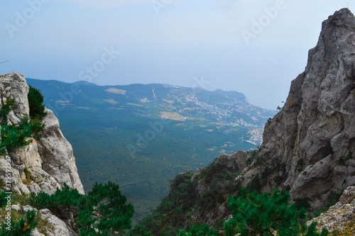 Aerial view of stone rock, cliff Ai-Petri in Crimea, Russia. Highest mountain and tourist attraction. Hanging bridge on Ai-Petri over the abyss with green trees, forest © SymbiosisArtmedia