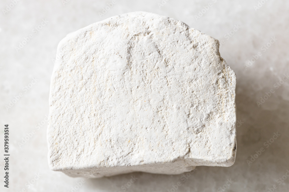 closeup of sample of natural mineral from geological collection - unpolished Chalk stone on white marble background from Voronezh region, Russia closeup of sample of natural mineral from geological collection - unpolished Chalk stone on white marble background from Voronezh region, Russia