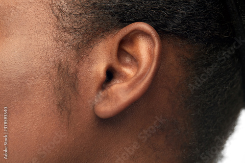 hearing, health and beauty concept - close up of african american woman's ear