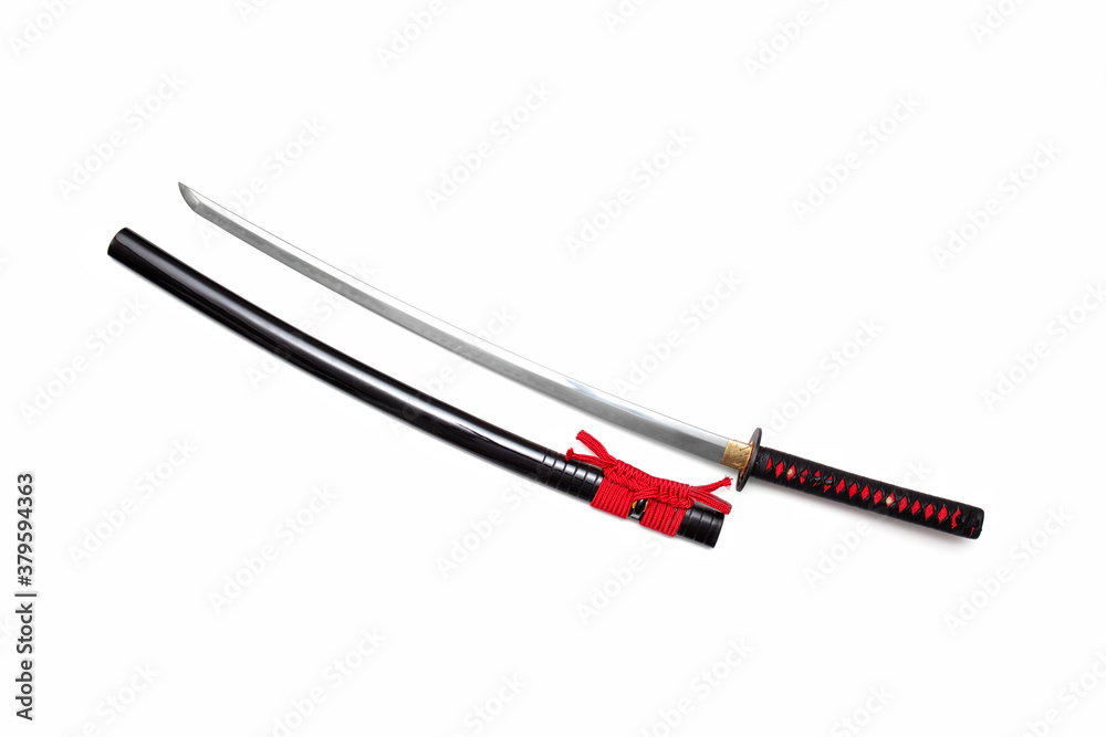 Japanese sword with red cord steel fitting and shiny black scabbard on white background. Selective focus. Japanese sword with red cord steel fitting and shiny black scabbard on white background. Selective focus.