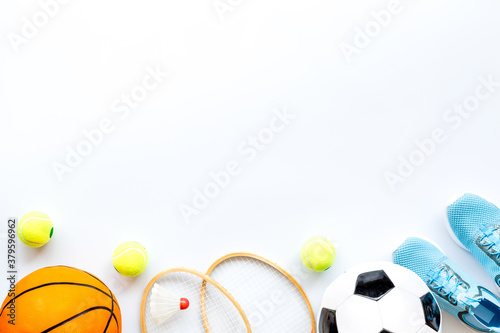 Sport games equipment - balls, sneakers, rackets - on white top view copy space