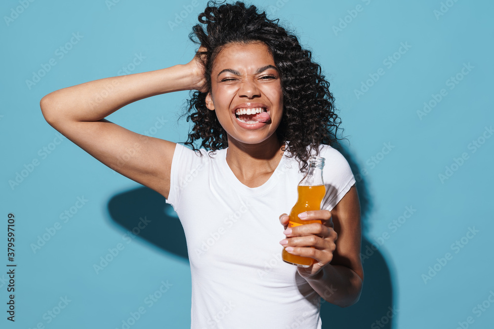 Image of african american woman showing her tongue while drinking soda Image of african american woman showing her tongue while drinking soda