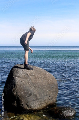 Boy on stone in the Baltic Sea