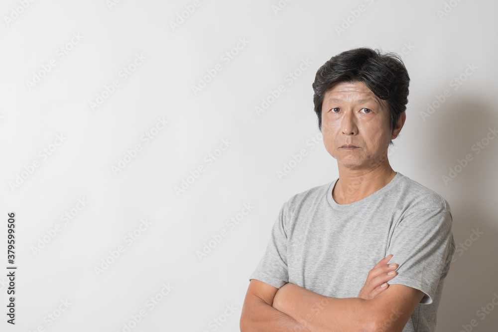腕組みしたTシャツ姿の中年男性 腕組みしたTシャツ姿の中年男性