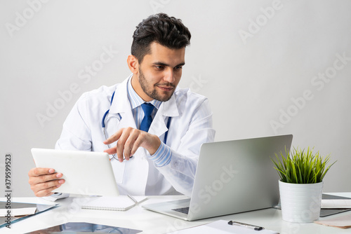 Young arab internist working with tablet computer