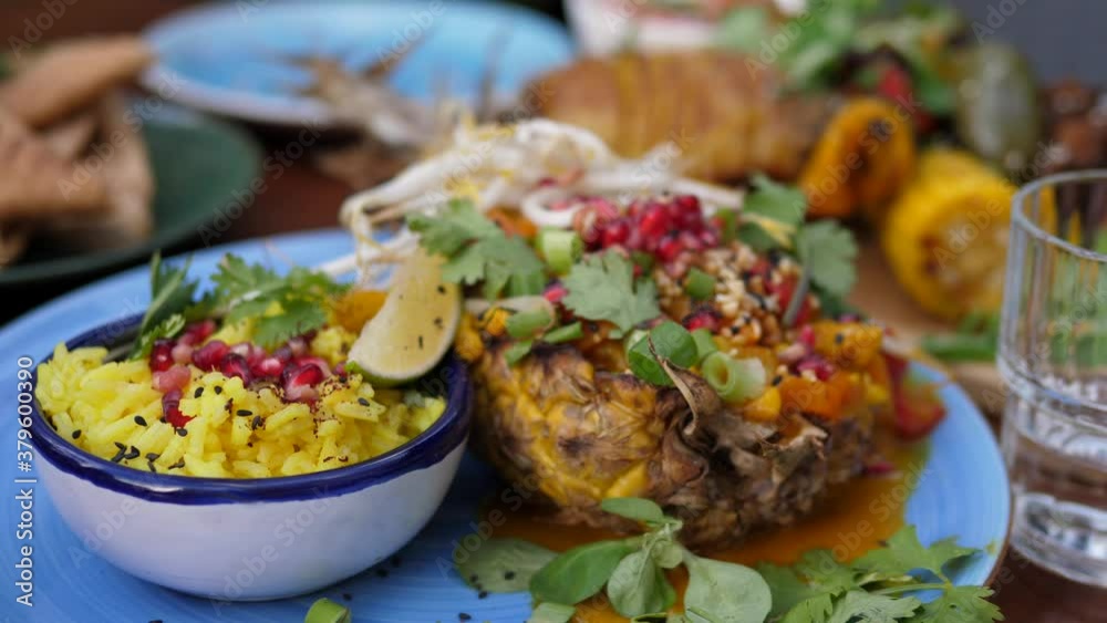 Vegan street food in trendy Asian style. Creamy coconut thai curry served in a pineapple with a rice on a side. Vegan street food in trendy Asian style. Creamy coconut thai curry served in a pineapple with a rice on a side.