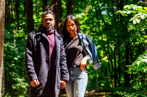 african american man with mixed race asian woman walking in the park