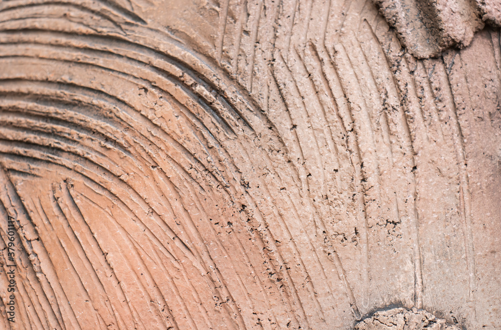 Naklejka premium Wavy clay wall texture and clay house background.