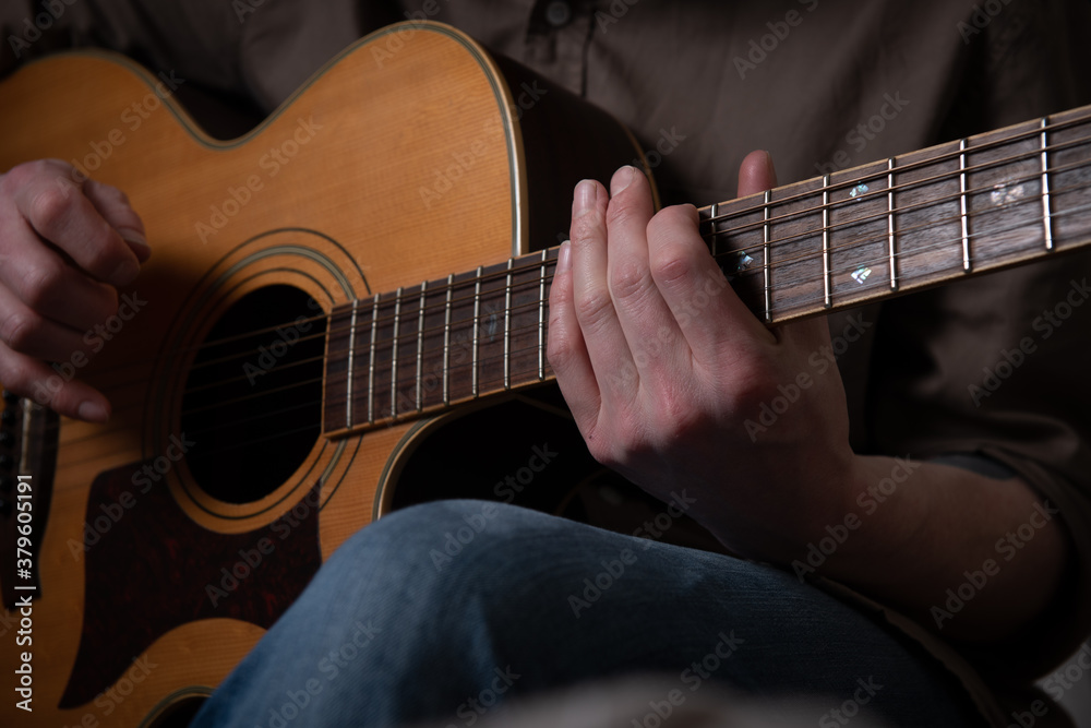 Fototapeta premium Person playing acoustic guitar