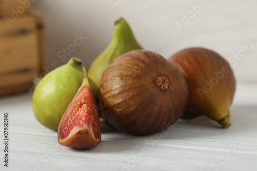 Fototapeta Naklejka Na Ścianę i Meble -  Tasty raw cut and whole figs on white table, closeup