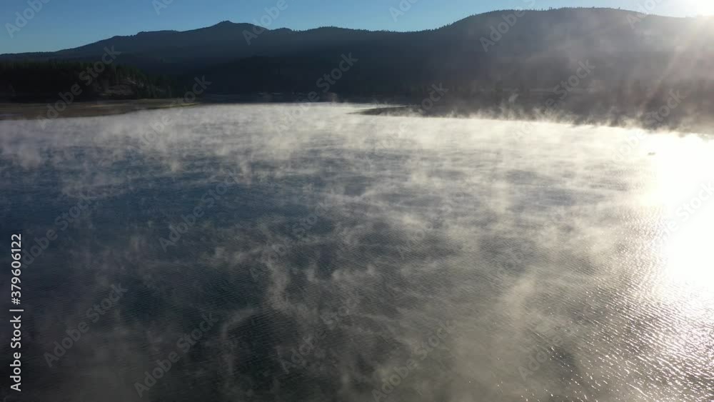 lake fog or tule fog over mountain lake surrounded by law rolling hills under blue sky during sunrise, Stampede Reservoir, California lake fog or tule fog over mountain lake surrounded by law rolling hills under blue sky during sunrise, Stampede Reservoir, California