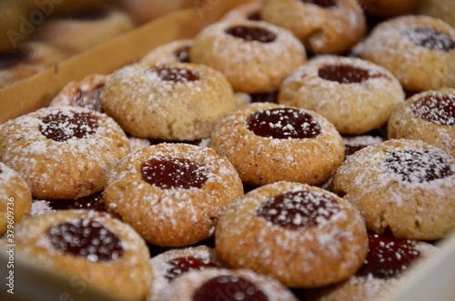 Traditional homemade German Christmas cookies Husarenkrapferl (Hussar donuts) or Engelsaugen (Eyes of an Angel), red currant jam filling, powdered sugar on top
