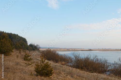 Sunny morning landscape with river and green fields