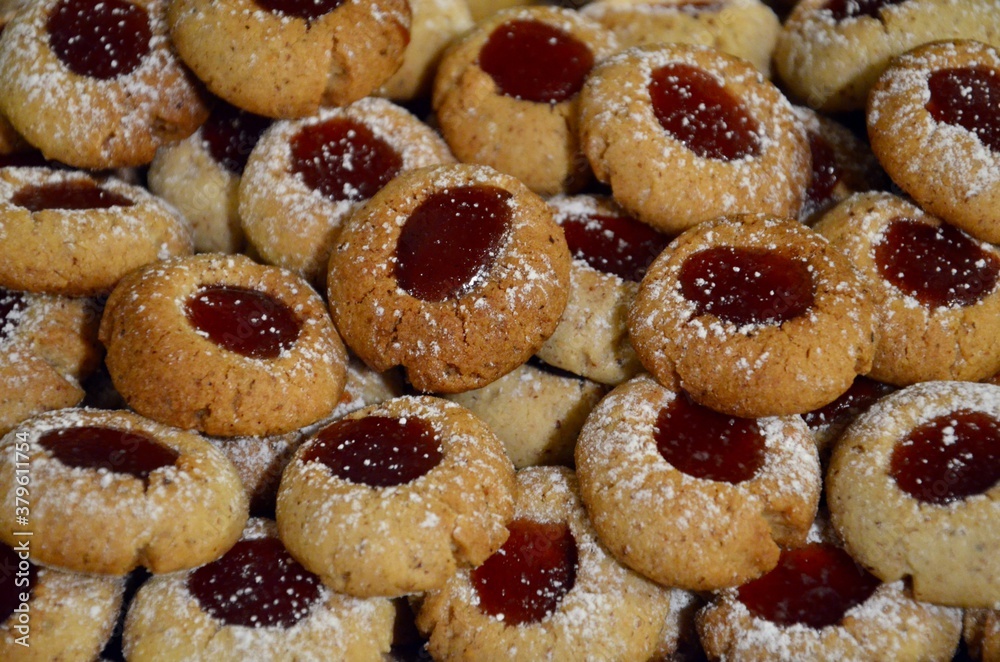 Traditional homemade German Christmas cookies Husarenkrapferl (Hussar donuts) or Engelsaugen (Eyes of an Angel), red currant jam filling, powdered sugar on top
