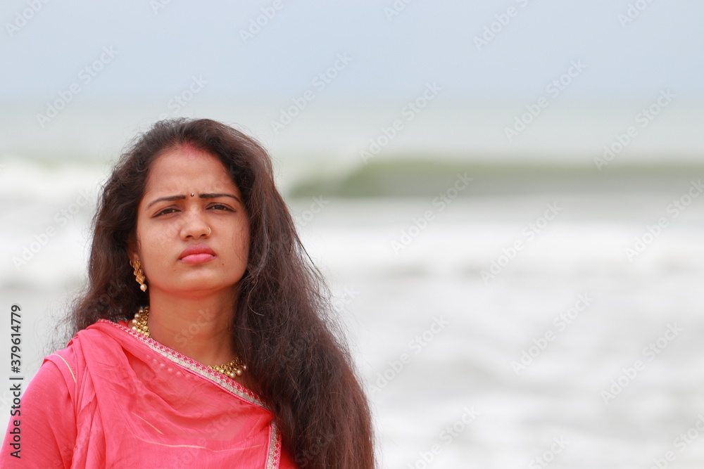 A beautiful South Indian model poses on Chennai's Merina coast and defocused towards hind ocean natural background