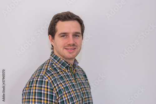 Photo of a young and attractive man wearing a shirt smiling at the camera looking very professional. Casual business man, corporative.