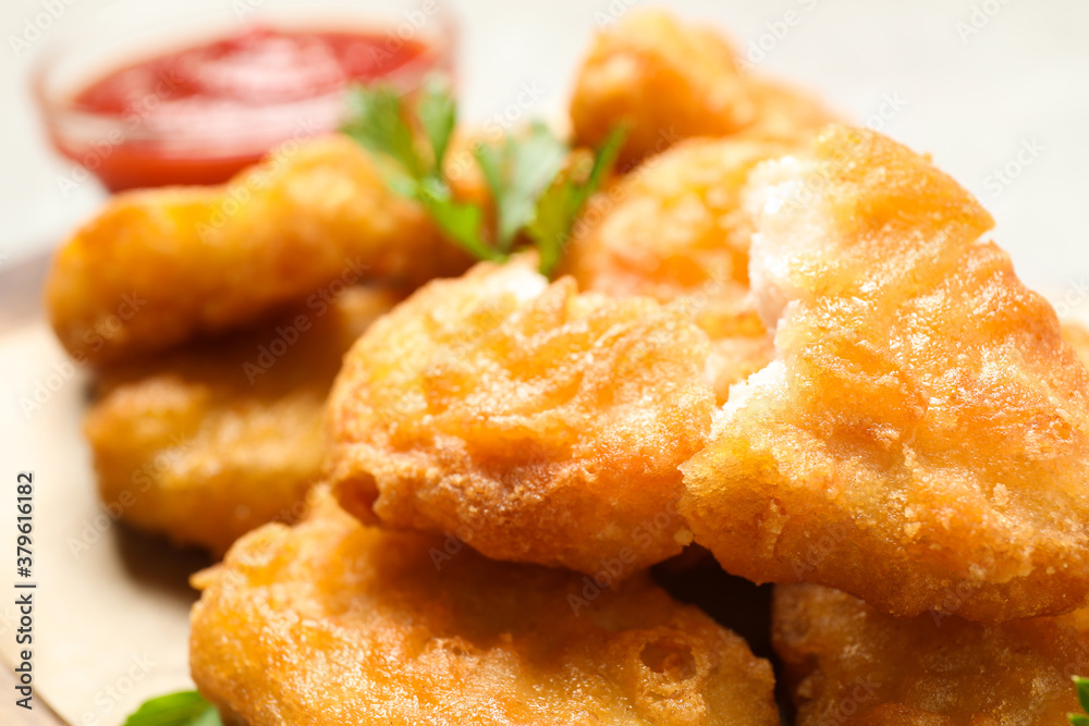 Tasty fried chicken nuggets on light table, closeup