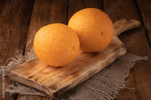 Eco fruit - fresh orange orange on wooden background, vegan food