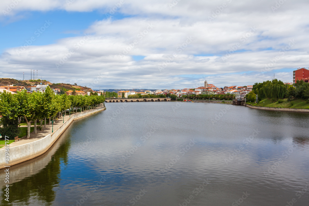 Urban landscape of the city of Mirandela in the north of Portugal. Panoramic view of the banks of the river Tua with the traditional Roman bridge and the historic center with its church tower.