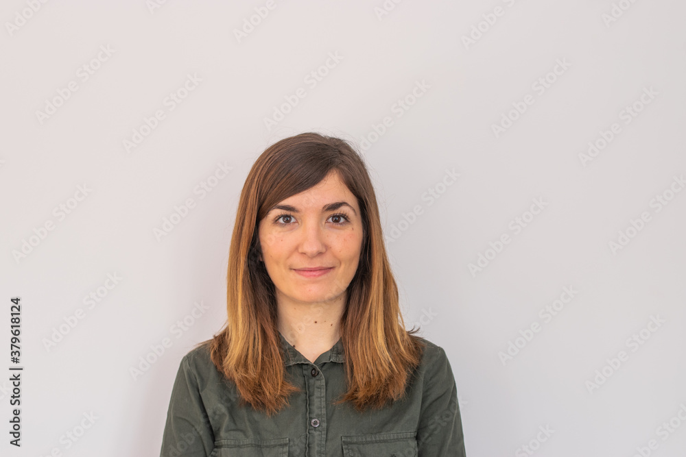 Obraz premium Photo of a young and attractive woman looking corporative with a shirt smiling at the camera, looking professional and ready to do bussiness with a white background
