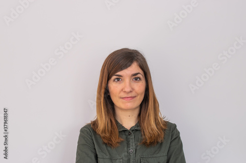 Photo of a young and attractive woman looking corporative with a shirt smiling at the camera, looking professional and ready to do bussiness with a white background © Irene Castro Moreno