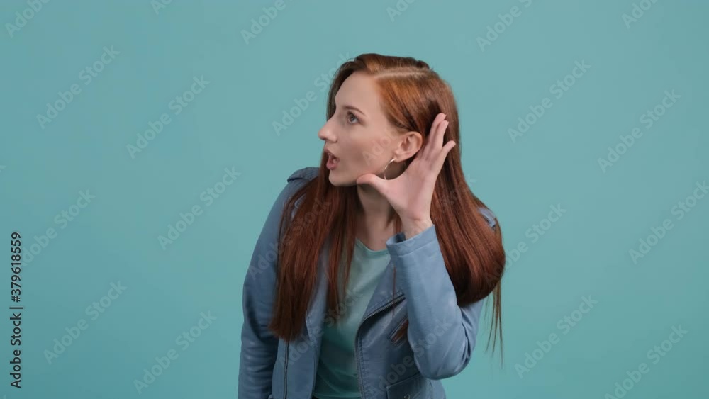 Curious young woman try to hear you with hand near ear. Girl want to listen the rumor and smile. Curious young woman try to hear you with hand near ear. Girl want to listen the rumor and smile.