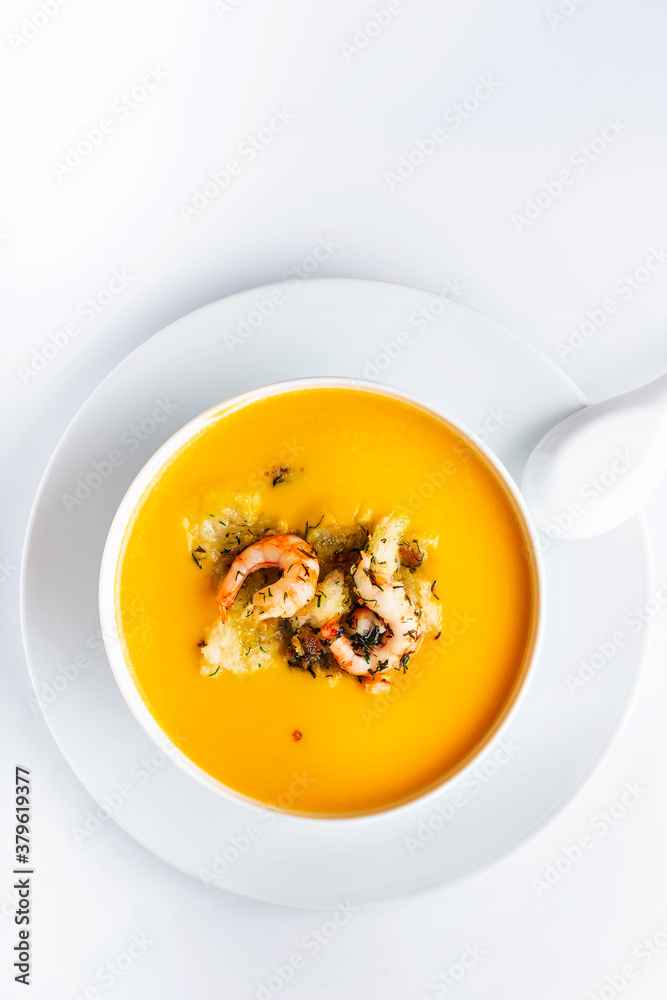 Diet pumpkin soup with shrimp, crouton, turmeric and greens. Healthy food. White background. Diet pumpkin soup with shrimp, crouton, turmeric and greens. Healthy food. White background.