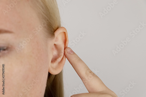 Darwin's tubercle on the ear. The girl at the reception at the plastic surgeon, shows the auricle. photo