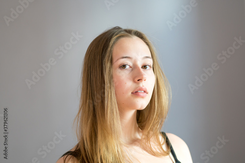 Obraz na plátne Portrait of a cute teenage girl wearing a black camisole posing looking at the c