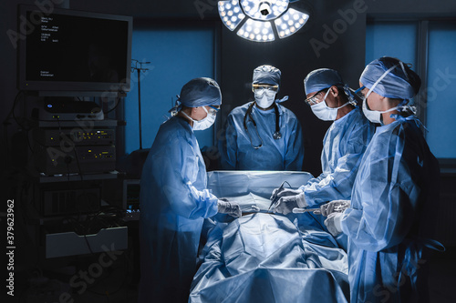 Diverse team of surgeons performing surgery on patient in hospital operating room.