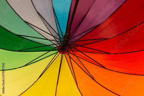 A multi-colored umbrella with stripes in rainbow colors (LGBT concept).