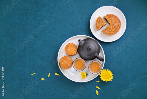 Moon cake for Mid-Autumn Festival, delicious beautiful fresh mooncake on a plate over blue background table, top view, flat lay layout design concept. photo