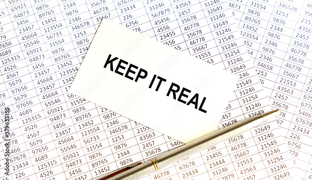 Obraz premium KEEP IT REAL text on paper sheet with chart, dice, spectacles, pen, laptop and blue and yellow push pin on wooden table - business, banking, finance and investment concept