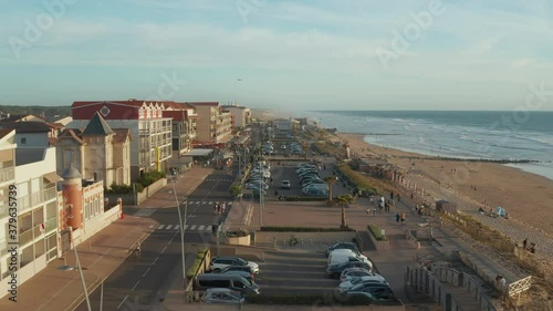 Small Beach Town Village Lacanau Promenade in South of France at Sunset, Slow Aerial high angle forward photo