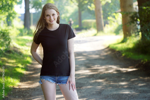 Hübsche junge Frau trägt T-Shirt in Weiß mit Textfreiraum oder Copy Space für Bedruck, Design oder Logo © Dan Race