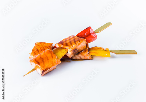 Japanese Salmon Skewers with bell pepper served with sauce. Yakitori Salmon isolated on white background. Pan Asian dish isolation. Fish Kusiyaki photo