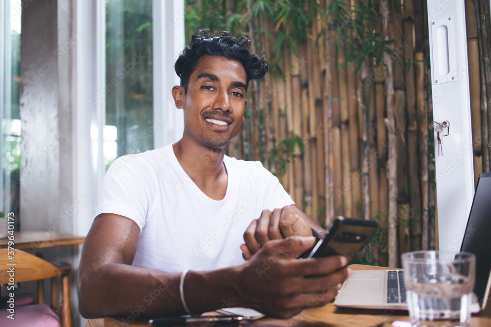 Delighted male texting cellphone in restaurant Delighted male texting cellphone in restaurant