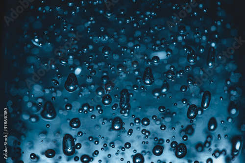 Bubbles of different shapes in dark blue color  water droplets and abstract background. Bubbles pattern and illumination