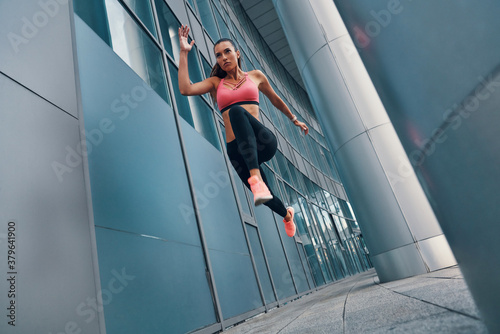 Valokuva Beautiful fit young woman in sports clothing hovering in air while exercising ou