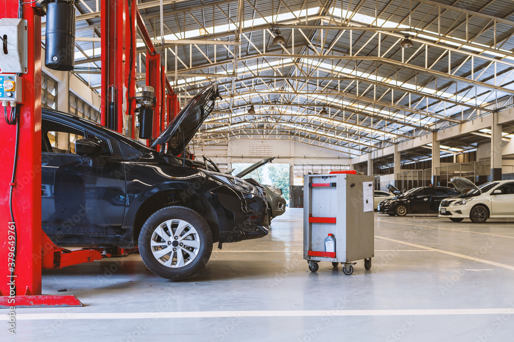 Fototapeta premium car in automobile repair service center with soft-focus and over light in the background