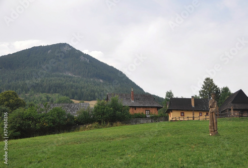 VLKOLINEC, SLOVAKIA, EUROPE, SUMMER. Views of the beautiful and touristic town of Vlkolinec, it is a Unesco Heritage. It is surrounded by mountains. At the main entrance there are some wooden figures.