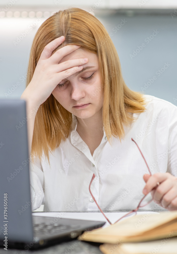 Sad teen girl have a headache after homework
