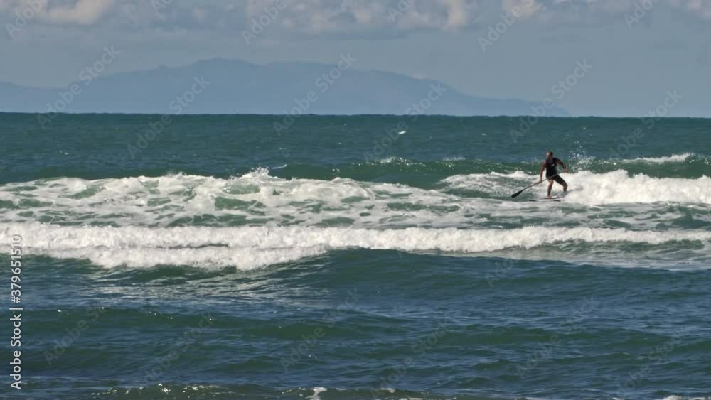 Stand Up Paddle: Man with Black Shirt Surfing on the Waves - slow motion Stand Up Paddle: Man with Black Shirt Surfing on the Waves - slow motion