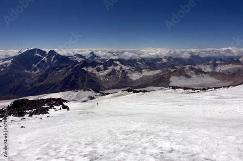 Climbing Elbrus. A view from the slopes of Elbrus to the surrounding mountain peaks covered with snow. © Anna
