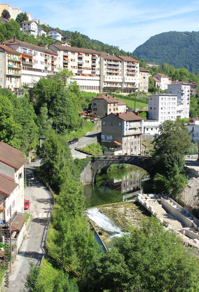View of the picturesque town of Sainte Claude in the Haut Jura region of France. Appartment buildings overlooking the river.