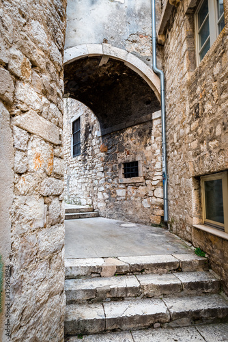 Medieval narrow street with a turn in Sibenik, Croatia