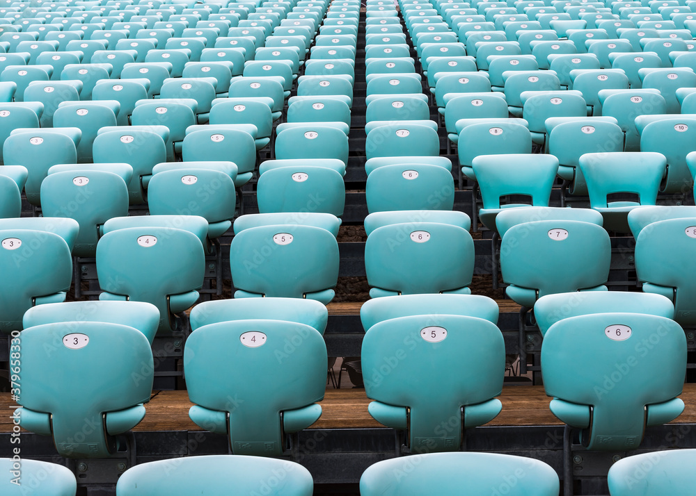 Obraz premium The rows of numbered turquoise chairs stretching into the distance
