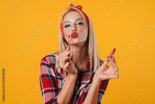 Image of pleased charming pinup girl applying lip gloss